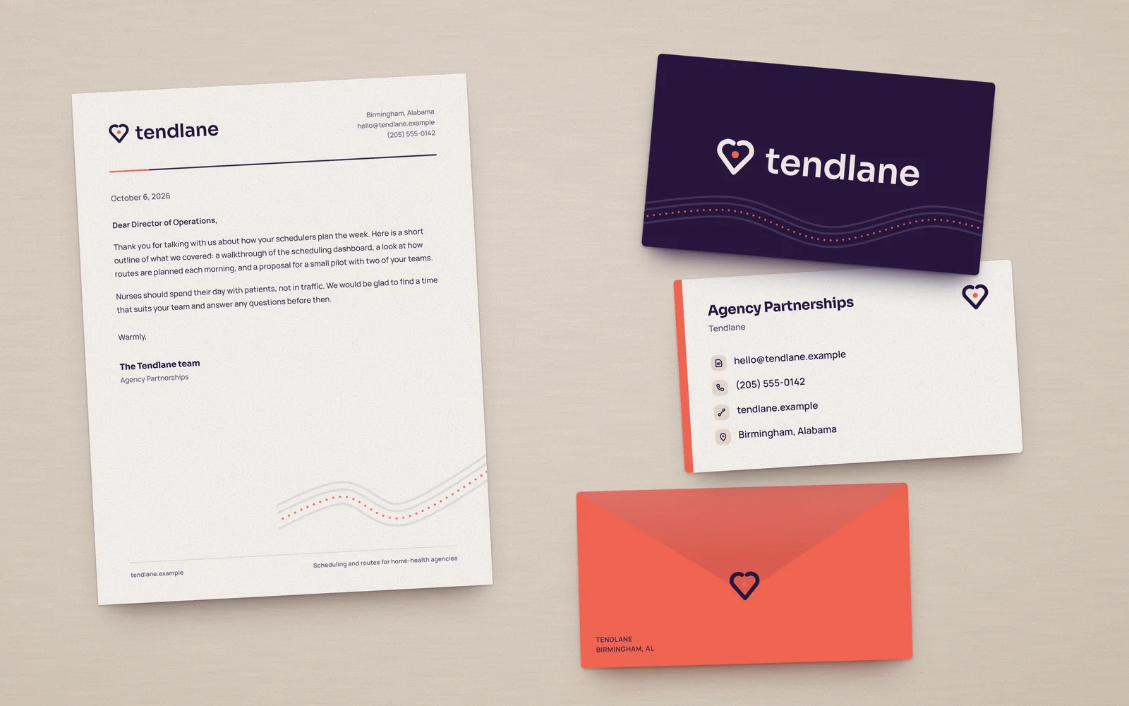 Tendlane letterhead, a plum business card with the reversed logo, a white card back with contact lines and a coral edge, and a coral envelope with the heart mark, laid on a warm textured surface.